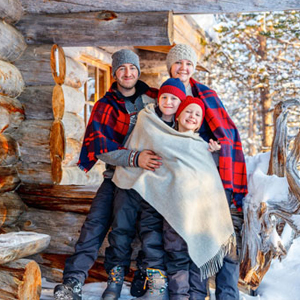 family outside cabin smiling