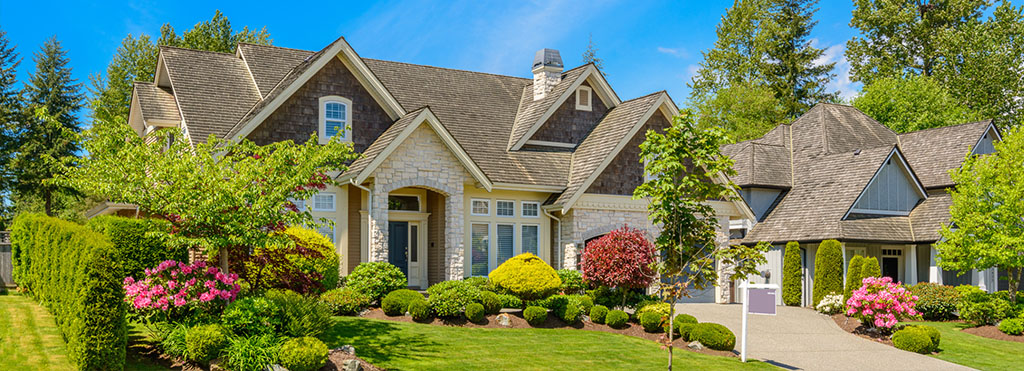 Large suburban house with stone and wood exterior - www.compassinsurancegroup.com